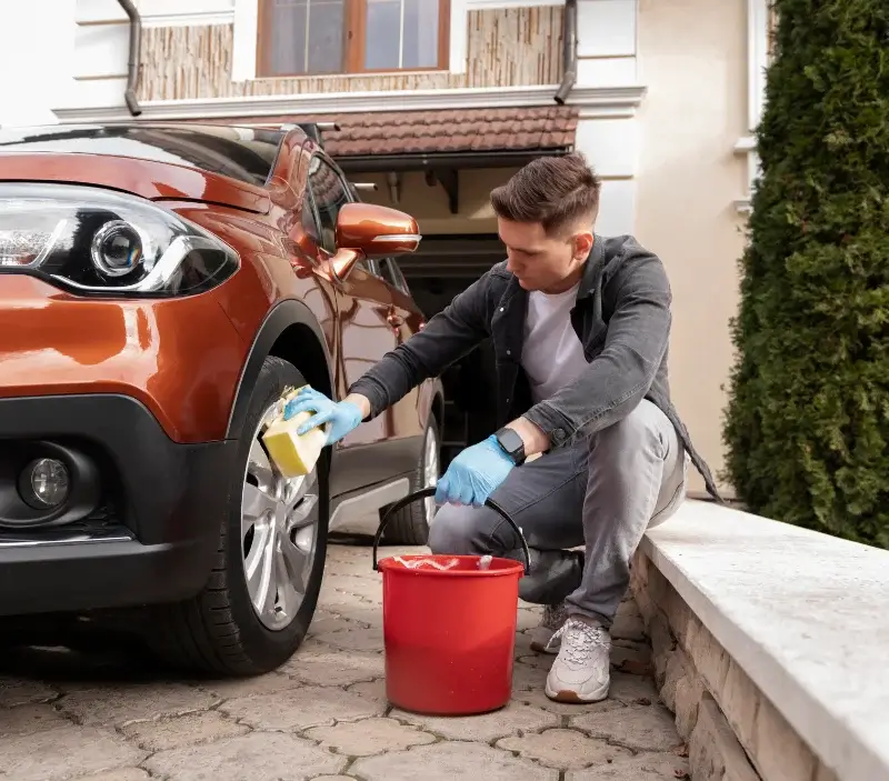 Lavage auto à domicile Plaisir : professionnel intervenant sur un véhicule